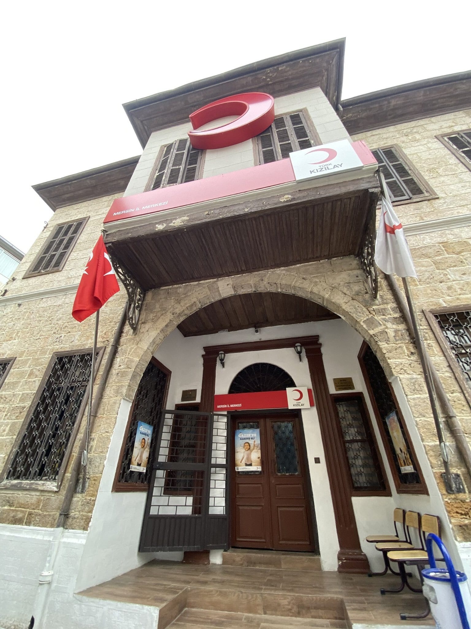 Fachada de um edifício histórico com o emblema do Crescente Vermelho sobre a porta, na Turquia