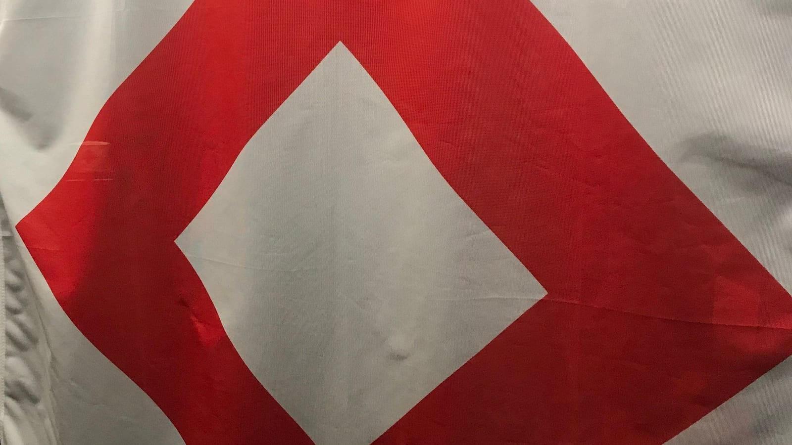 Bandeira branca com o cristal vermelho, uma moldura vermelha em forma de losango com o centro vazio