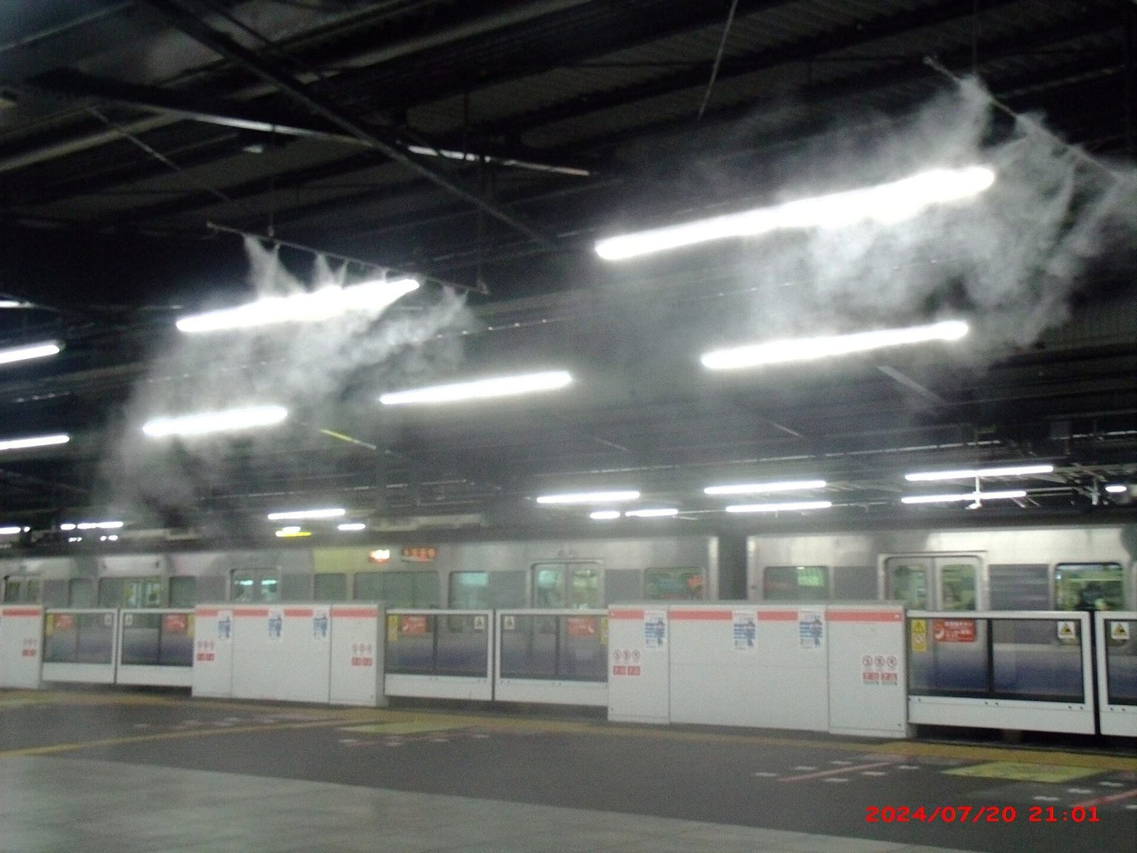 Nebulizadores de água resfriam a plataforma de uma estação de trem em dia de calor