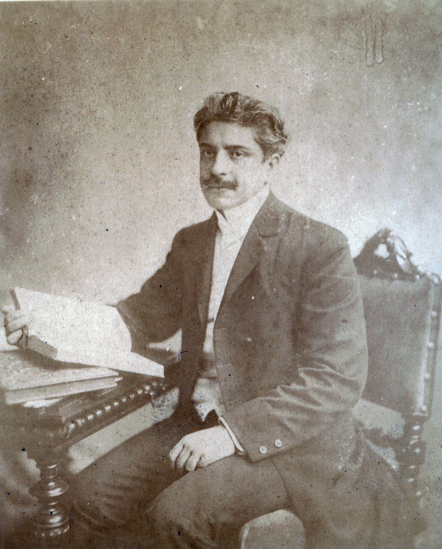 Oswaldo Cruz sentado à mesa, com livros, em foto antiga